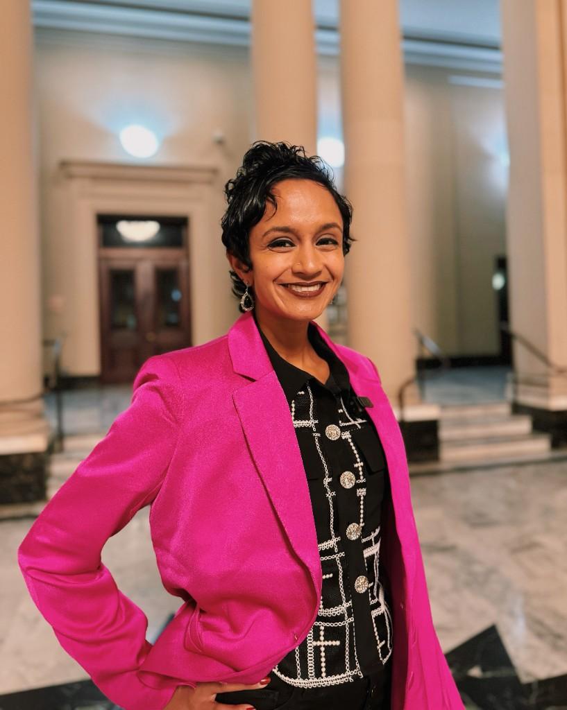 Professional portrait of Janani Ramachandran in a pink blazer