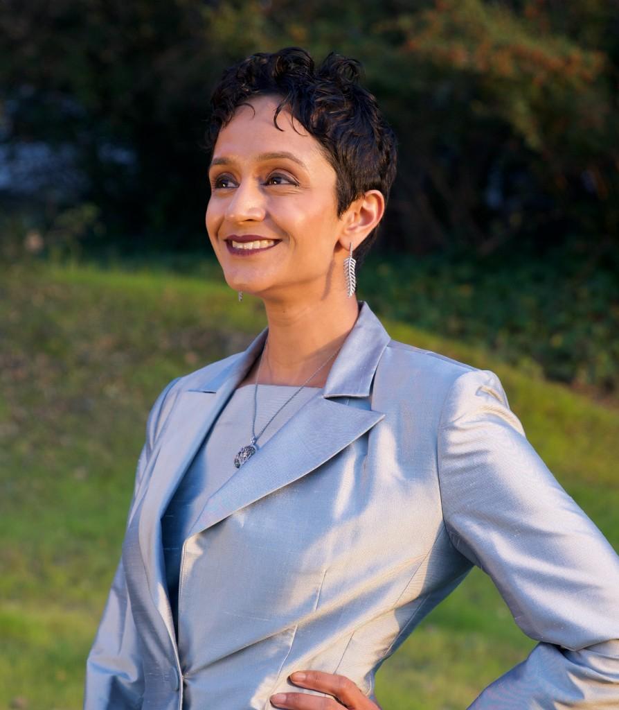 Professional portrait of Janani Ramachandran in a silver suit